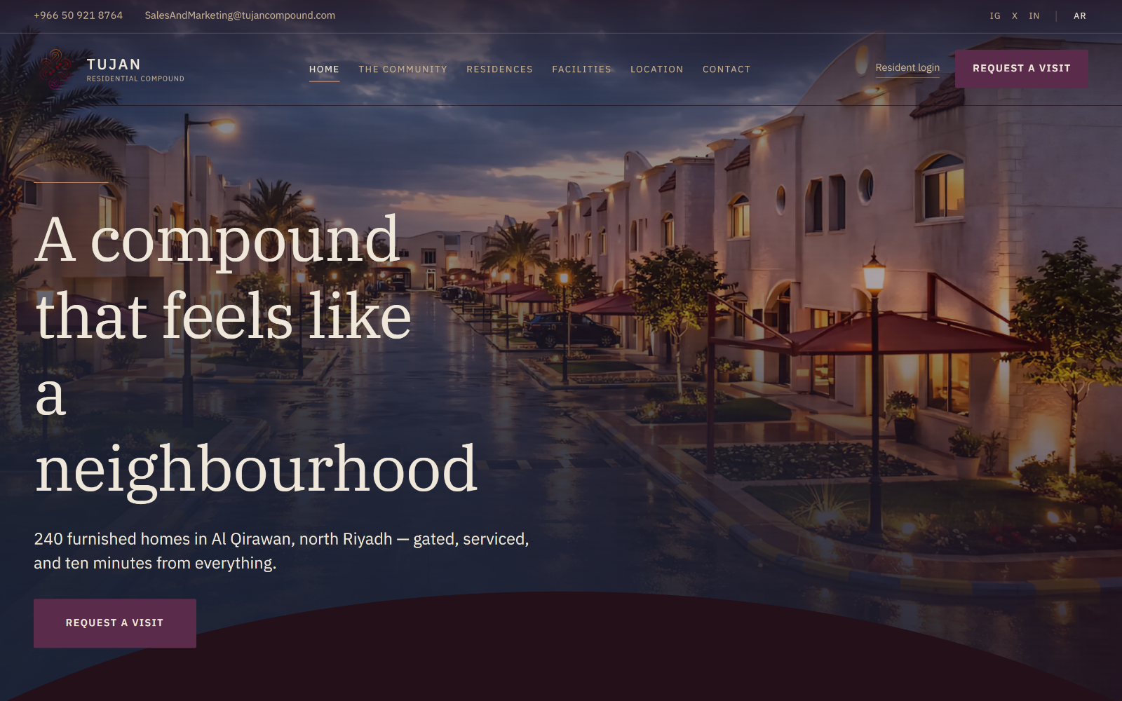 The Tujan Compound homepage: the headline "A compound that feels like a neighbourhood" over a photograph of the lit compound at dusk.